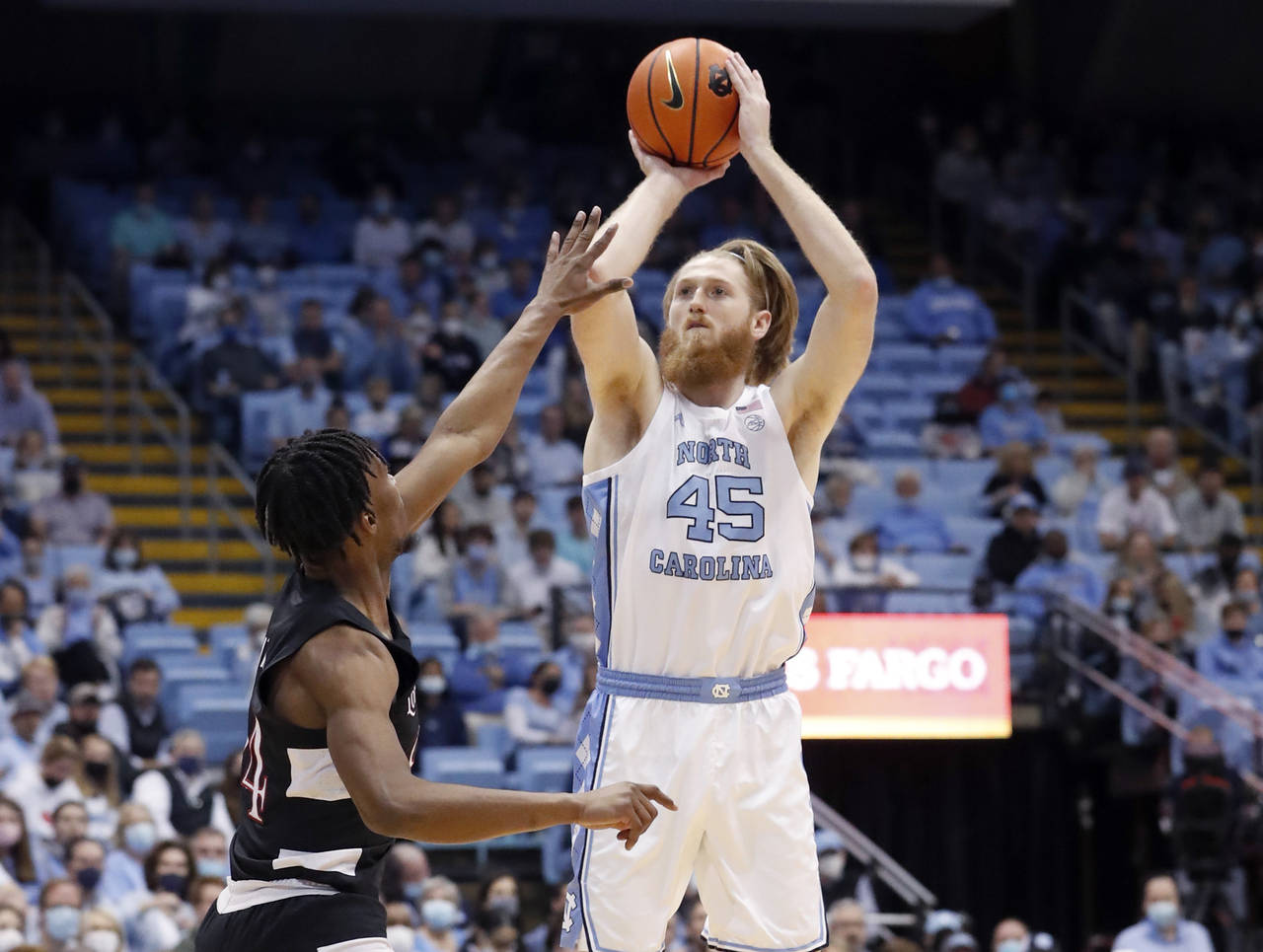 North Carolina's Brady Manek (45) shoots as Louisville's Jae'Lyn Withers, left, defends during the ...