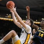 
              Iowa forward Filip Rebraca, left, fights for a rebound with Michigan forward Moussa Diabate (14) during the second half of an NCAA college basketball game, Thursday, Feb. 17, 2022, in Iowa City, Iowa. Michigan won 84-79. (AP Photo/Charlie Neibergall)
            