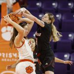 
              Clemson forward Hannah Hank, left, tries to keep the ball from Louisville forward Emily Engstler (21) in the third quarter of an NCAA college basketball game in Clemson, S.C., Thursday, Feb. 3, 2022. (AP Photo/Nell Redmond)
            