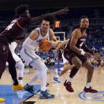 
              UCLA guard Jules Bernard, center, grabs a rebound next to Arizona State center Enoch Boakye, left, and forward Kimani Lawrence (4) during the second half of an NCAA college basketball game Monday, Feb. 21, 2022, in Los Angeles. (AP Photo/Marcio Jose Sanchez)
            