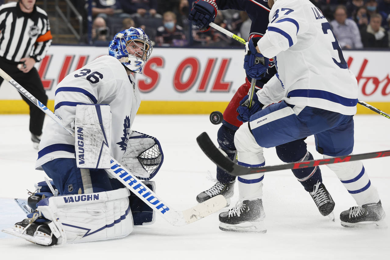 Toronto Maple Leafs' Jack Campbell, left, makes a save against the Columbus Blue Jackets during the...