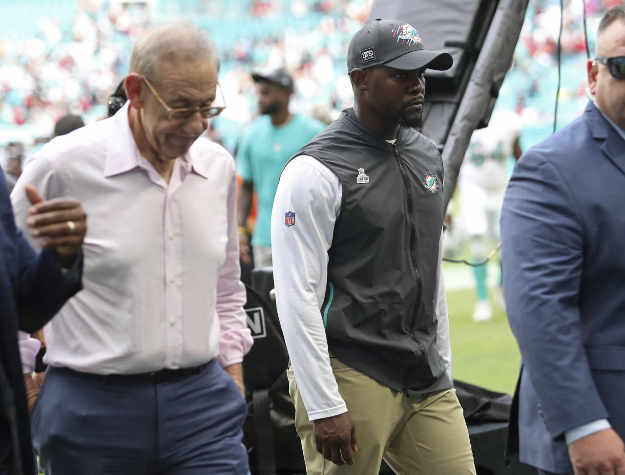 FILE - Miami Dolphins owner Stephen Ross, left, walks off the field next to coach Brian Flores afte...