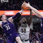 
              Purdue forward Trevion Williams, center, battles for a rebound against Northwestern forward Robbie Beran, left, and center Ryan Young during the first half of an NCAA college basketball game in Evanston, Ill., Wednesday, Feb. 16, 2022. (AP Photo/Nam Y. Huh)
            