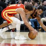 
              Atlanta Hawks guard Trae Young (11) and Cleveland Cavaliers center Evan Mobley (4) battle for a loose ball during the first half of an NBA basketball game Tuesday, Feb. 15, 2022, in Atlanta. (AP Photo/John Bazemore)
            