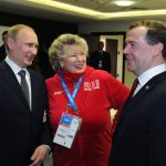 
              FILE- Russian President Vladimir Putin, left, and Prime Minister Dmitry Medvedev, right, listen to figure skating coach Tatiana Tarasova in the presidential lounge before the 2014 Winter Olympics closing ceremony, in Sochi, Russia, Sunday, Feb. 23, 2014. The 2022 Beijing Games' first major scandal has managed to involve 15-year-old figure skater Kamila Valieva who has tested positive for using a banned heart medication that may cost her Russia-but-not-really-Russia team a gold medal in team competition."This is some kind of a fake," said Tarasova. "She's only 15, what do you mean doping?" (RIA Novosti Kremlin, Mikhail Klimentyev, Presidential Press Service/Pool Photo via AP)
            