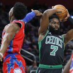 
              Boston Celtics guard Jaylen Brown (7) passes the ball while being guarded by Detroit Pistons guard Hamidou Diallo, left, during the first half of an NBA basketball game Saturday, Feb. 26, 2022, in Detroit. (AP Photo/Duane Burleson)
            
