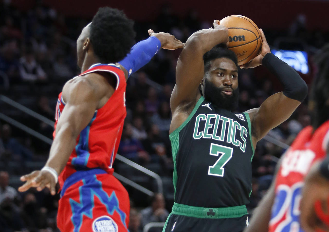 Boston Celtics guard Jaylen Brown (7) passes the ball while being guarded by Detroit Pistons guard ...