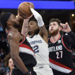 
              Memphis Grizzlies guard Ja Morant (12) drives between Portland Trail Blazers forward Justise Winslow, left, and center Jusuf Nurkic (27) in the second half of an NBA basketball game Wednesday, Feb. 16, 2022, in Memphis, Tenn. (AP Photo/Brandon Dill)
            