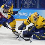 
              Slovakia's Juraj Slafkovsky (20) goes for the puck in front of Sweden goalkeeper Magnus Hellberg (35) during a preliminary round men's hockey game at the 2022 Winter Olympics, Friday, Feb. 11, 2022, in Beijing. (AP Photo/Petr David Josek)
            