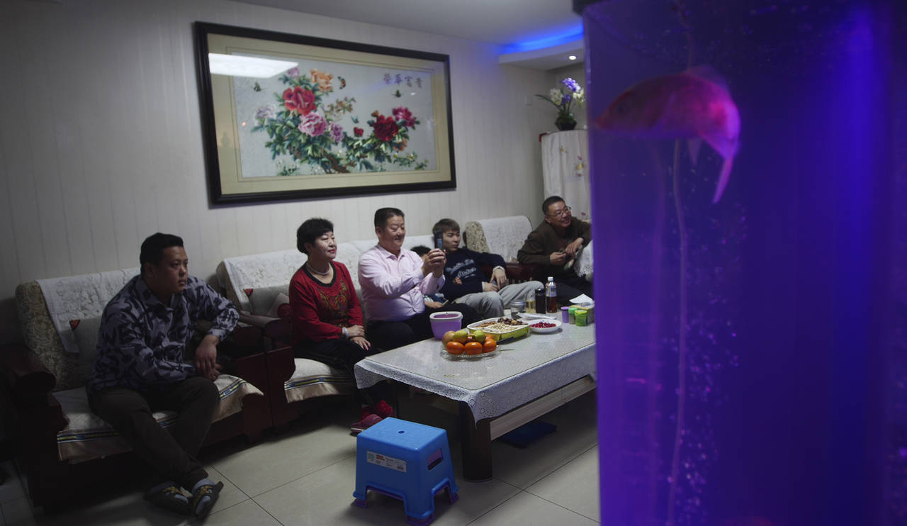 The family of Liu Wenbin, center, watches the opening ceremony of the Beijing Olympics on a televis...