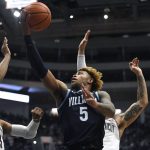 
              Villanova's Justin Moore shoots as Connecticut's Isaiah Whalen, left, and Tyrese Martin, back, defend during the first half of an NCAA college basketball game Tuesday, Feb. 22, 2022, in Hartford, Conn. (AP Photo/Jessica Hill)
            