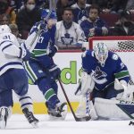 
              Vancouver Canucks goalie Thatcher Demko (35) stops Toronto Maple Leafs' John Tavares (91) as Canucks' Travis Hamonic (27) defends during the second period of an NHL hockey game in Vancouver, British Columbia, Saturday, Feb. 12, 2022. (Darryl Dyck/The Canadian Press via AP)
            