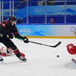 
              Canada's Adam Tambellini (15) shoots against Canada goalkeeper Devon Levi (1) during a men's qualification round hockey game at the 2022 Winter Olympics, Tuesday, Feb. 15, 2022, in Beijing. (AP Photo/Matt Slocum)
            