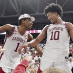 
              Arkansas players JD Notae (1) and Jaylin Williams (10) celebrate with fans after defeating Auburn 80-76 in overtime during an NCAA college basketball game Tuesday, Feb. 8, 2022, in Fayetteville, Ark. (AP Photo/Michael Woods)
            