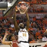 
              Oklahoma forwards Jalen Hill (1) and Ethan Chargois (15) watch as Oklahoma State forward Moussa Cisse (33) dunks in the first half of an NCAA college basketball game Saturday, Feb. 5, 2022, in Stillwater, Okla. Oklahoma State won 64-55. (AP Photo/Brody Schmidt)
            