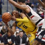 
              Marquette's Greg Elliott (5) is fouled by Connecticut's Tyrese Martin in the first half of an NCAA college basketball game, Tuesday, Feb. 8, 2022, in Hartford, Conn. (AP Photo/Jessica Hill)
            