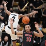 
              Colorado guard Keeshawn Barthelemy (3) leaps by Utah guard Marco Anthony who passes the ball in the second half of an NCAA college basketball game Saturday, Feb. 12, 2022, in Boulder, Colo. (AP Photo/David Zalubowski)
            