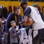 
              Los Angeles Lakers forward LeBron James signs an autograph for a fan during a practice session for the NBA All-Star basketball game in Cleveland, Saturday, Feb. 19, 2022. (AP Photo/Charles Krupa)
            