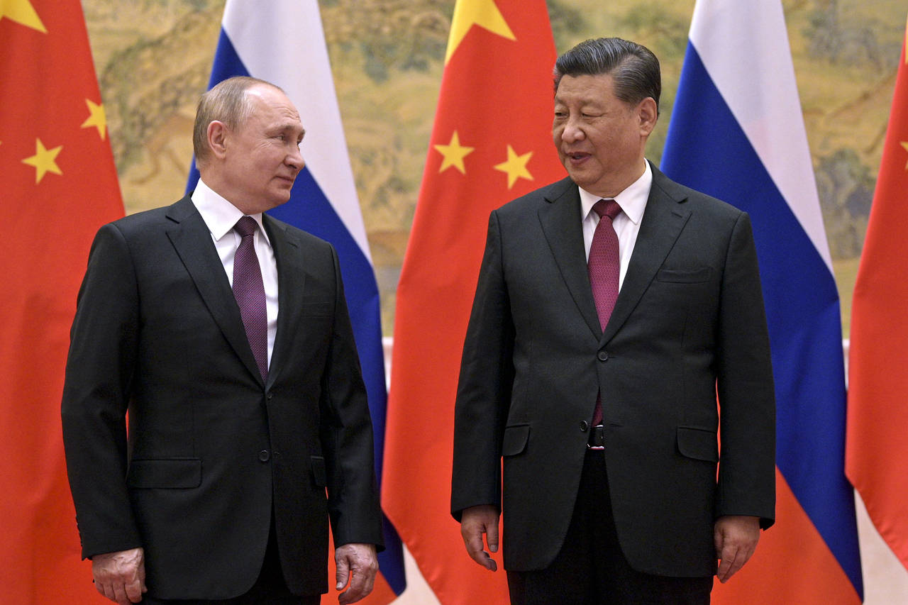 Chinese President Xi Jinping, right, and Russian President Vladimir Putin talk to each other during...