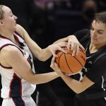 
              Connecticut's Paige Bueckers, left, and Providence's Kylee Sheppard, right, fight for the ball in the first half of an NCAA college basketball game, Sunday, Feb. 27, 2022, in Storrs, Conn. (AP Photo/Jessica Hill)
            