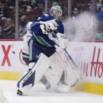 
              Vancouver Canucks goalie Thatcher Demko, front, plays the puck away from Seattle Kraken's Joonas Donskoi, of Finland, during the first period of an NHL hockey game in Vancouver, British Columbia, Monday, Feb. 21, 2022. (Darryl Dyck/The Canadian Press via AP)
            