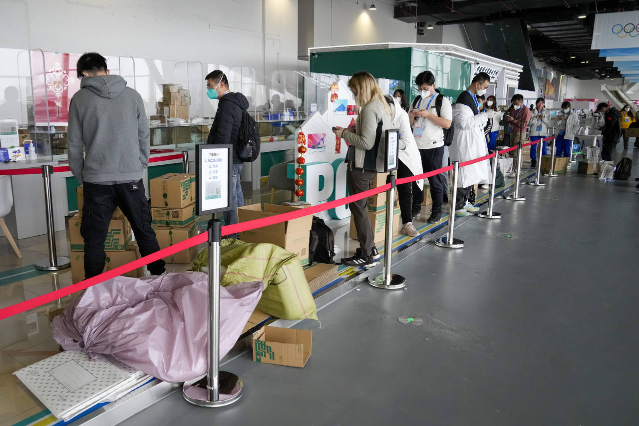 People queue with their parcels outside the post office at the Main Press Center at the 2022 Winter...