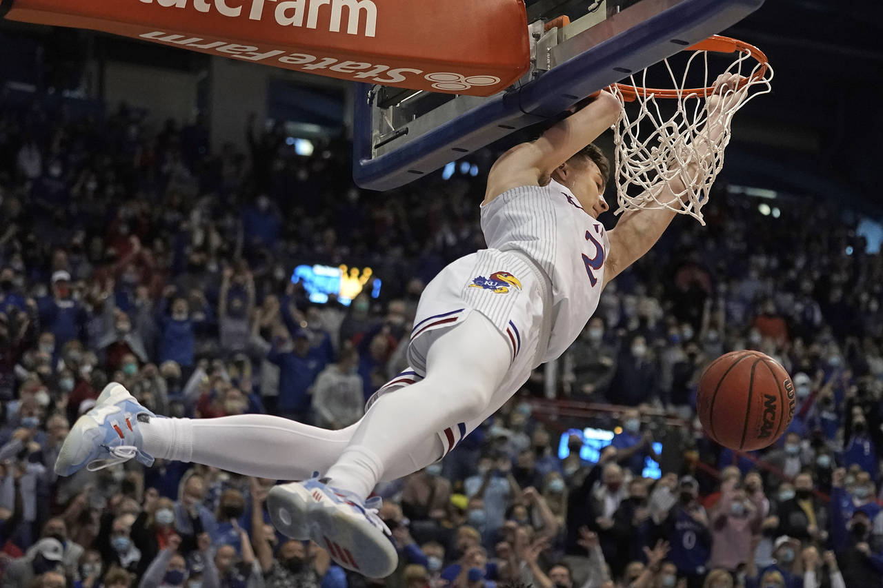 Kansas guard Christian Braun dunks the ball during the first half of an NCAA college basketball gam...