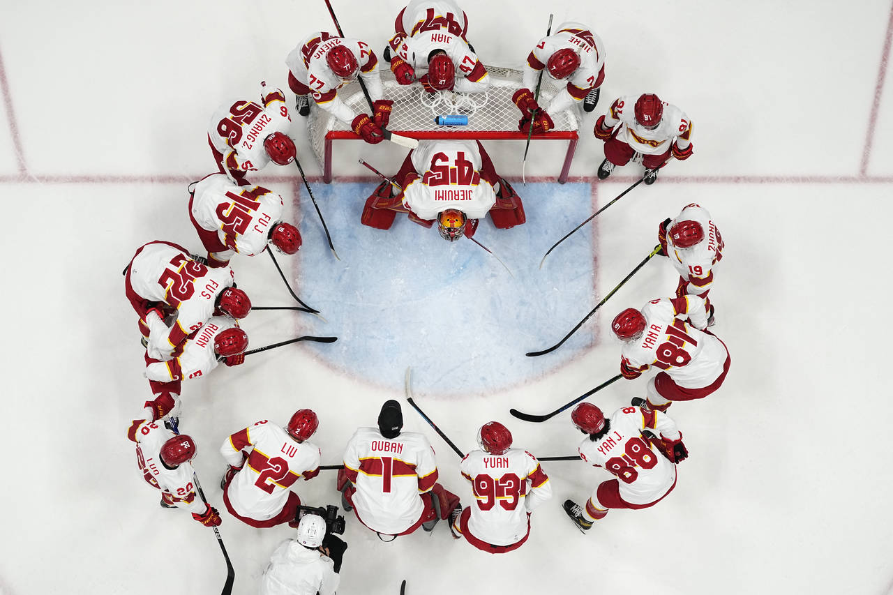 Team China players gather before a preliminary round men's hockey game against Germany at the 2022 ...
