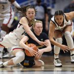 
              Marquette's Liza Karlen, center, and Connecticut's Nika Mühl, left, and Azzi Fudd, right, chase the ball during the first half of an NCAA college basketball game Wednesday, Feb. 23, 2022, in Hartford, Conn. (AP Photo/Jessica Hill)
            