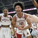 
              Arkansas players, from left, JD Notae, Jaylin Williams and Kamani Johnson (20) celebrate after defeating No. 1 Auburn 80-76 in overtime following an NCAA college basketball game Tuesday, Feb. 8, 2022, in Fayetteville, Ark. (AP Photo/Michael Woods)
            