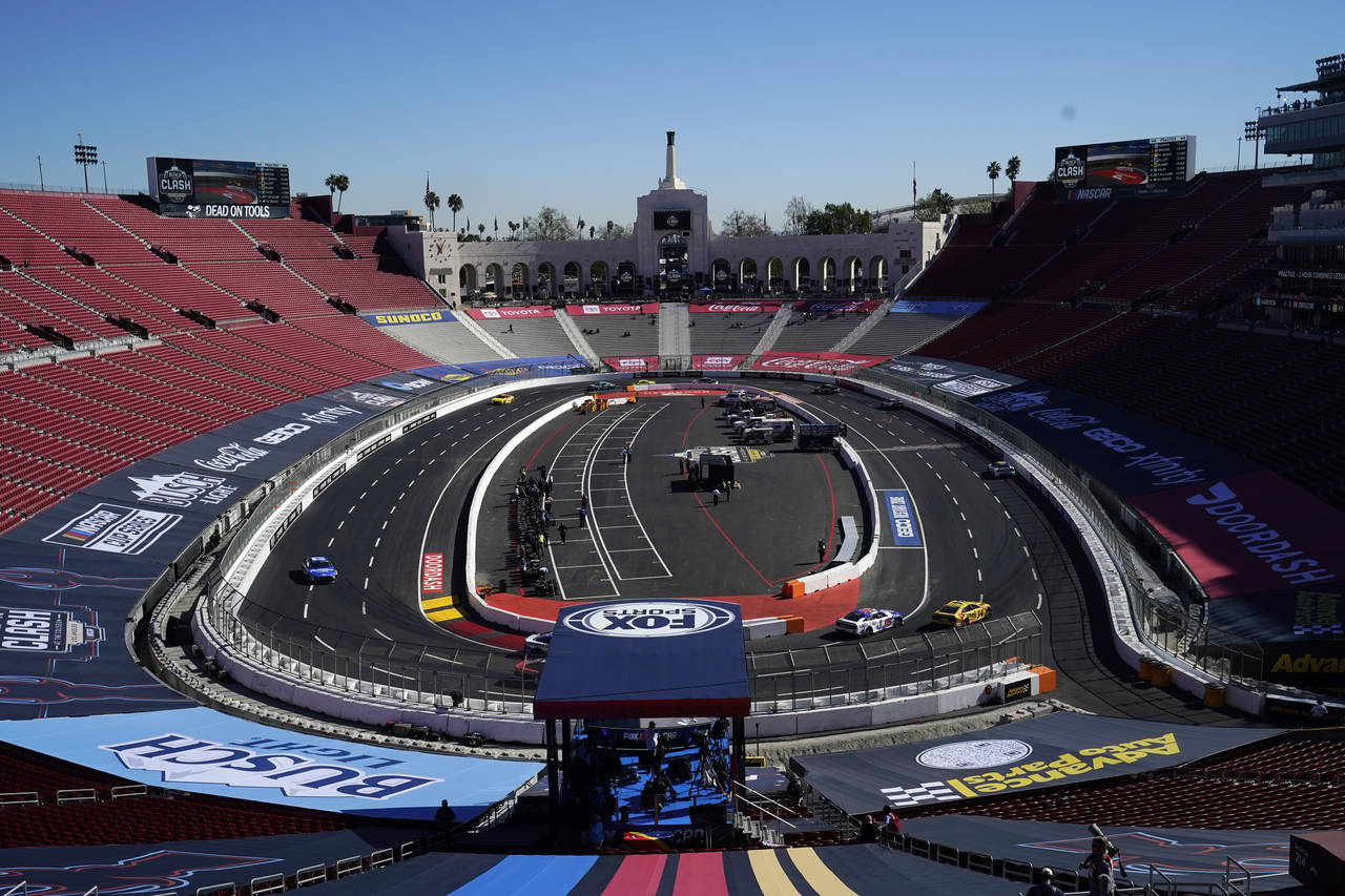 Competitors race around the track during a practice session at the Los Angeles Memorial Coliseum, S...