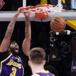 
              Los Angeles Lakers forward Anthony Davis, left, dunks as guard Austin Reaves watches during the first half of an NBA basketball game against the Utah Jazz Wednesday, Feb. 16, 2022, in Los Angeles. (AP Photo/Mark J. Terrill)
            