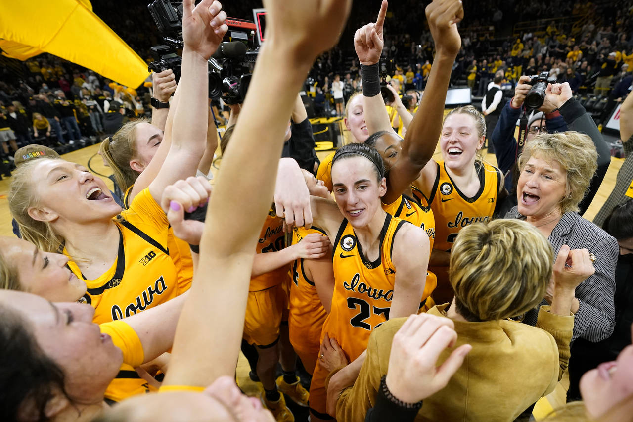 Iowa guard Caitlin Clark, center, celebrates with teammates after an NCAA college basketball game a...