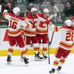 
              Calgary Flames' Nikita Zadorov (16), Oliver Kylington (58), Johnny Gaudreau (13) and Elias Lindholm (28) celebrate a goal scored by Kylington in the third period of an NHL hockey game against the Dallas Stars in Dallas, Tuesday, Feb. 1, 2022. (AP Photo/Tony Gutierrez)
            