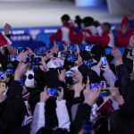 
              Olympic workers and volunteers hold up their smartphones to record a medal ceremony for the women's freestyle skiing big air at the 2022 Winter Olympics, Tuesday, Feb. 8, 2022, in Beijing. (AP Photo/Jae C. Hong)
            