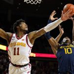 
              Iowa State guard Tyrese Hunter (11) fights for a rebound with West Virginia guard Malik Curry (10) during the second half of an NCAA college basketball game, Wednesday, Feb. 23, 2022, in Ames, Iowa. Iowa State won 84-81. (AP Photo/Charlie Neibergall)
            