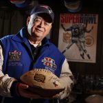 
              FILE — Donald Crisman poses with memorabilia from Super Bowls he has attended so far, Thursday, Jan. 25, 2018, at his home, in Kennebunk, Maine. Crisman, along with Tom Henschel, and Gregory Eaton have attended every Super Bowl since the first AFL-NFL World Championship held 55 years ago. The three men are meeting at the Super Bowl once again for this year's game, but future meetings are in question. (AP Photo/Robert F. Bukaty, File)
            
