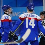 
              Slovakia's Juraj Slafkovsky (20) is congratulated by Peter Ceresnak (14) after Slafkovsky scored a goal against Latvia during a preliminary round men's hockey game at the 2022 Winter Olympics, Sunday, Feb. 13, 2022, in Beijing. (AP Photo/Matt Slocum)
            