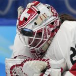 
              The puck hits the mask of Switzerland goalkeeper Andrea Braendli during the women's bronze medal hockey game against Finland at the 2022 Winter Olympics, Wednesday, Feb. 16, 2022, in Beijing. (AP Photo/Petr David Josek)
            