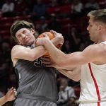 
              Utah center Branden Carlson, left, and Arizona forward Azuolas Tubelis vie for a rebound during the first half of an NCAA college basketball game Thursday, Feb. 24, 2022, in Salt Lake City. (AP Photo/Rick Bowmer)
            