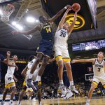 
              Michigan forward Moussa Diabate (14) fights for a rebound with Iowa guard Payton Sandfort (20) during the first half of an NCAA college basketball game, Thursday, Feb. 17, 2022, in Iowa City, Iowa. (AP Photo/Charlie Neibergall)
            