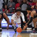 
              St. John's Stef Smith, center, dives for a loose ball during the first half of an NCAA college basketball game against Connecticut Sunday, Feb. 13, 2022, in New York. (AP Photo/Seth Wenig)
            