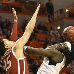
              Oklahoma State guard Isaac Likekele (13) shoots over Oklahoma forward Ethan Chargois (15) in the first half of an NCAA college basketball game, Saturday, Feb. 5, 2022, in Stillwater, Okla. Oklahoma State defeated rival Oklahoma 64-55. (AP Photo/Brody Schmidt)
            