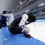 
              Erin Jackson of the United States reacts as coach Ryan Shimabukuro hugs teammates after winning the gold medal in the speedskating women's 500-meter race at the 2022 Winter Olympics, Sunday, Feb. 13, 2022, in Beijing. (AP Photo/Ashley Landis)
            