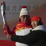 
              First Torch bearer Luo Zhihuan and his wife poses with the torch at the start of the torch relay for the 2022 Winter Olympics at the Olympic Forest Park in Beijing on Wednesday, Feb. 2, 2022. (AP Photo/Sam McNeil)
            