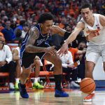 
              Duke forward Paolo Banchero, left, and Syracuse forward Cole Swider chase the ball during the first half of an NCAA college basketball game in Syracuse, N.Y., Saturday, Feb. 26, 2022. (AP Photo/Adrian Kraus)
            