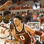 
              Oklahoma guard Jordan Goldwire (0) drives the ball past Oklahoma State guard Bryce Williams (14) in the second half of an NCAA college basketball game Saturday, Feb. 5, 2022, in Stillwater, Okla. Oklahoma State defeated rival Oklahoma 64-55. (AP Photo/Brody Schmidt)
            