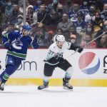 
              Vancouver Canucks' Elias Pettersson, left, of Sweden, and Seattle Kraken's Yanni Gourde vie for the puck during the first period of an NHL hockey game in Vancouver, British Columbia, Monday, Feb. 21, 2022. (Darryl Dyck/The Canadian Press via AP)
            