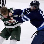 
              Winnipeg Jets' Adam Lowry (17) fights with Minnesota Wild's Marcus Foligno (17) during the third period of an NHL game in Winnipeg, Manitoba, Tuesday, Feb. 8, 2022. (Fred Greenslade/The Canadian Press via AP)
            