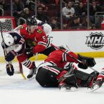 
              Chicago Blackhawks goaltender Arvid Soderblom, third from left, saves a shot as Columbus Blue Jackets center Boone Jenner, left, and Blackhawks defenseman Connor Murphy (5) battle for the puck during the first period of an NHL hockey game in Chicago, Thursday, Feb. 17, 2022. (AP Photo/Nam Y. Huh)
            